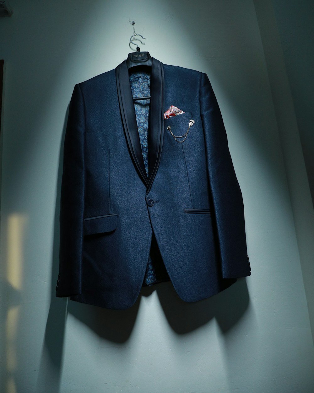 Veste de costume bleu nuit suspendue sur un cintre, prête à être restituée